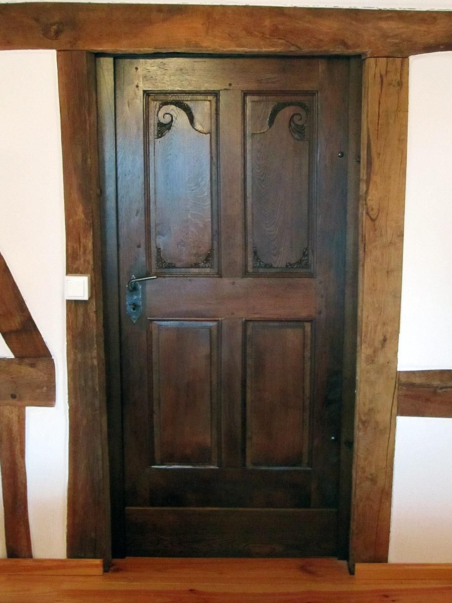 Eine Holztür mit einer weißen Wand dahinter