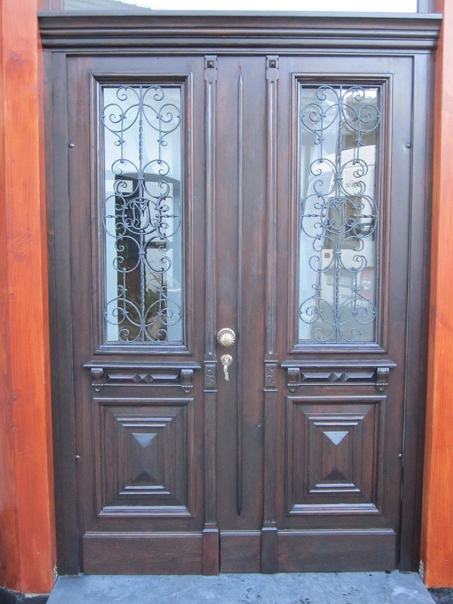Eine Holztür mit einem schmiedeeisernen Design darauf