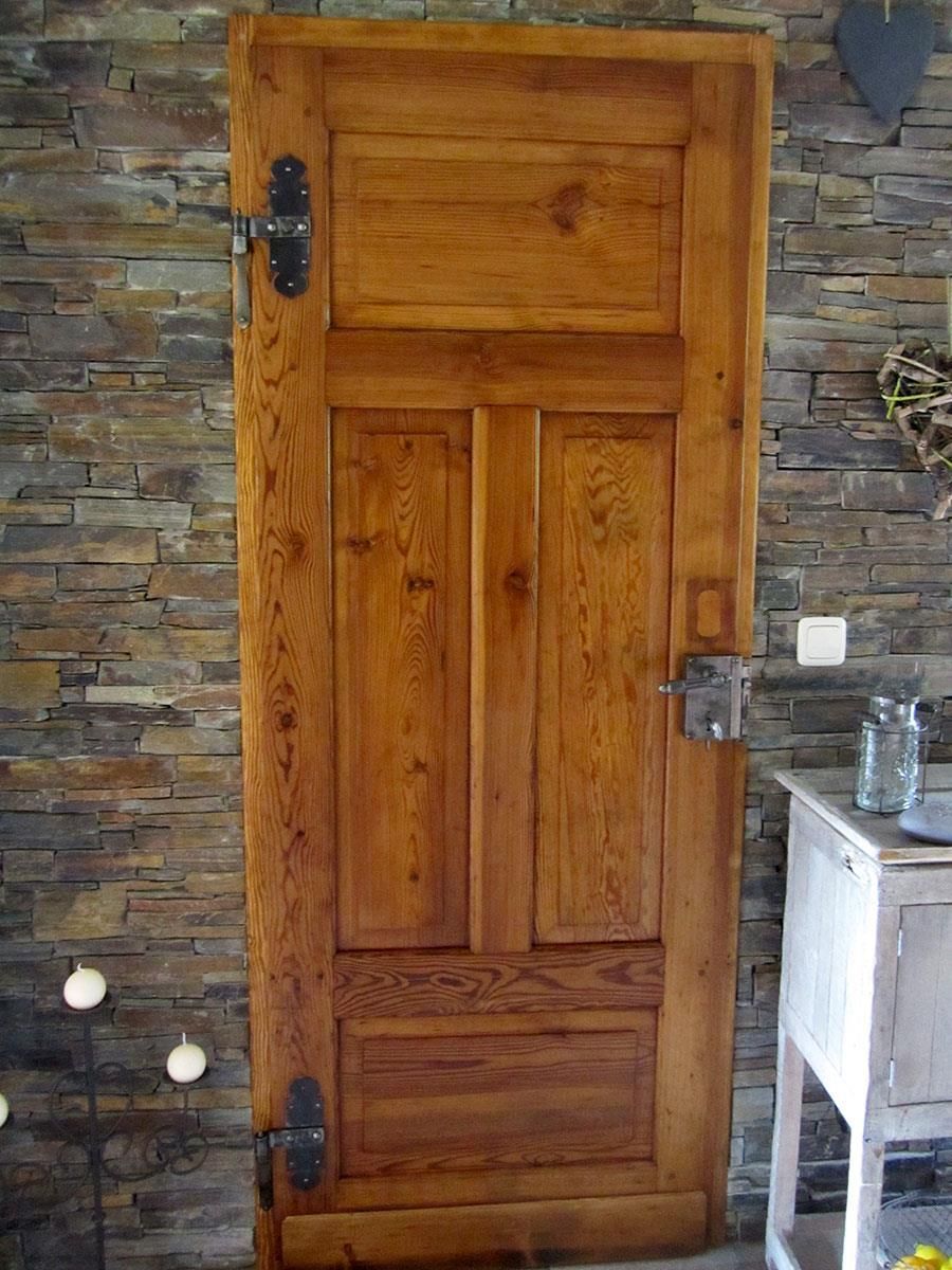 Eine Holztür vor einer Steinmauer