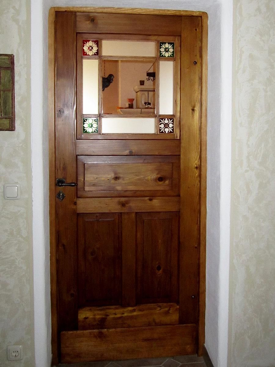 Eine Holztür mit einem Buntglasfenster