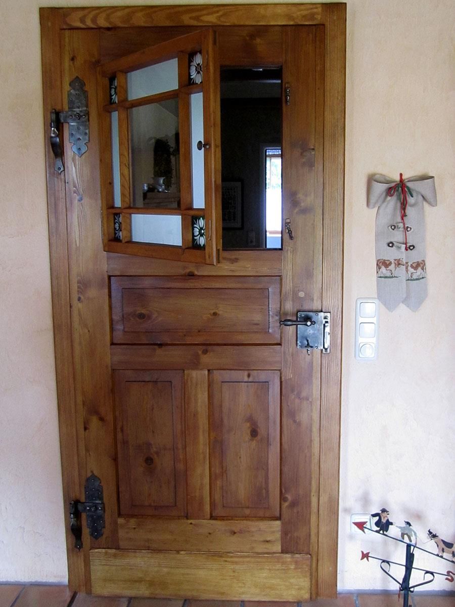 Eine Holztür mit einer Uhr an der Wand dahinter