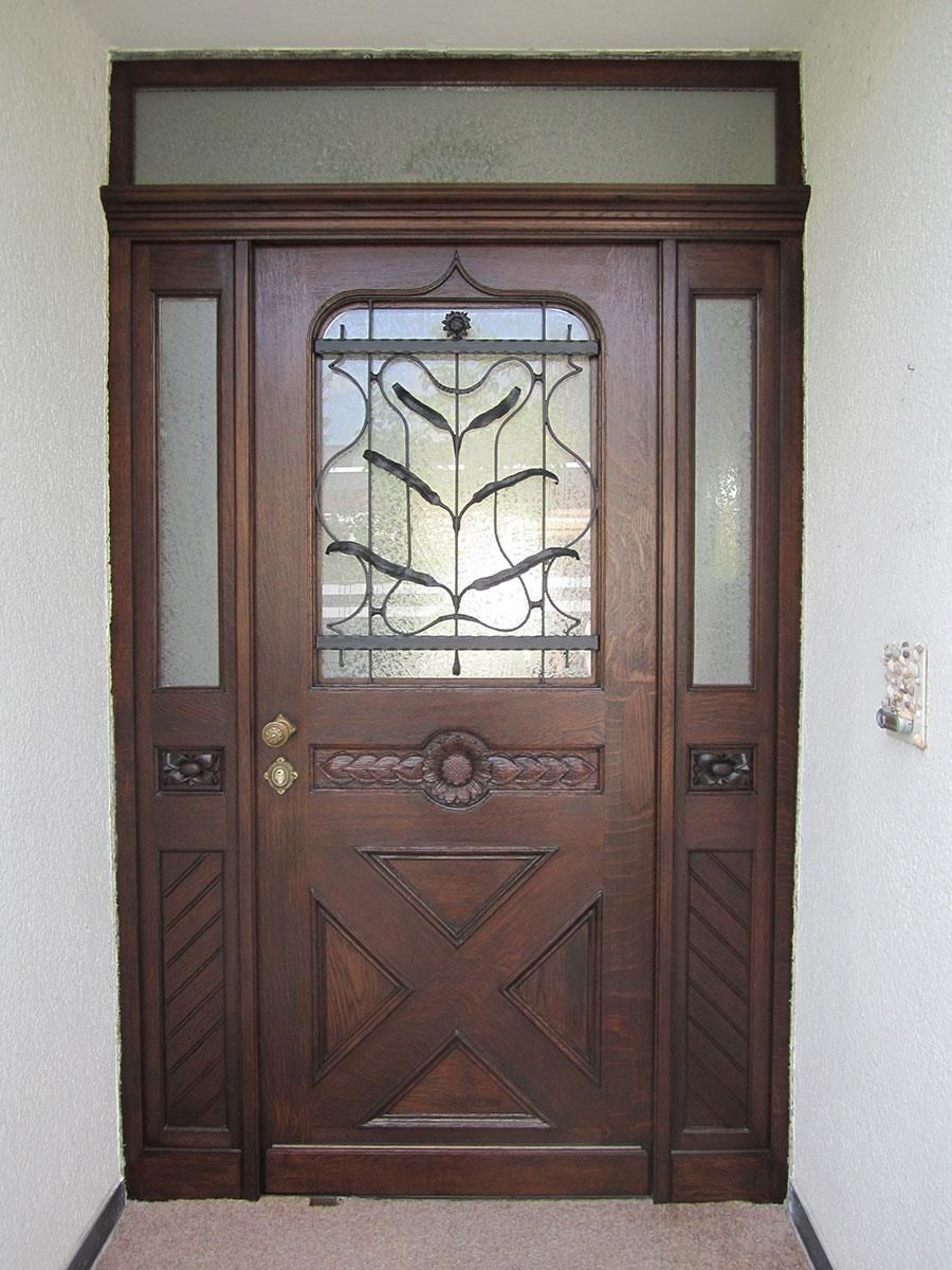 Eine Holztür mit einem Buntglasfenster