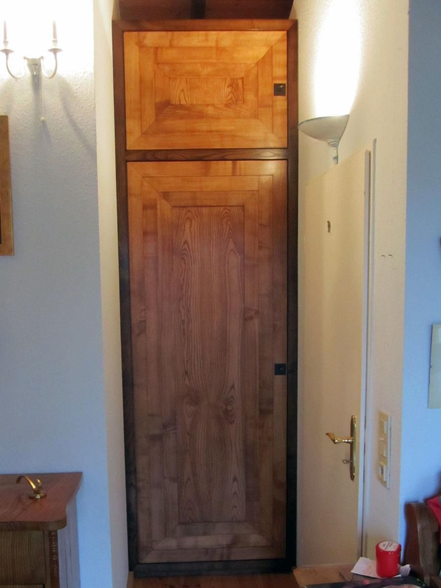 Eine Holztür in einem Raum mit einer Kerze auf einem Tisch