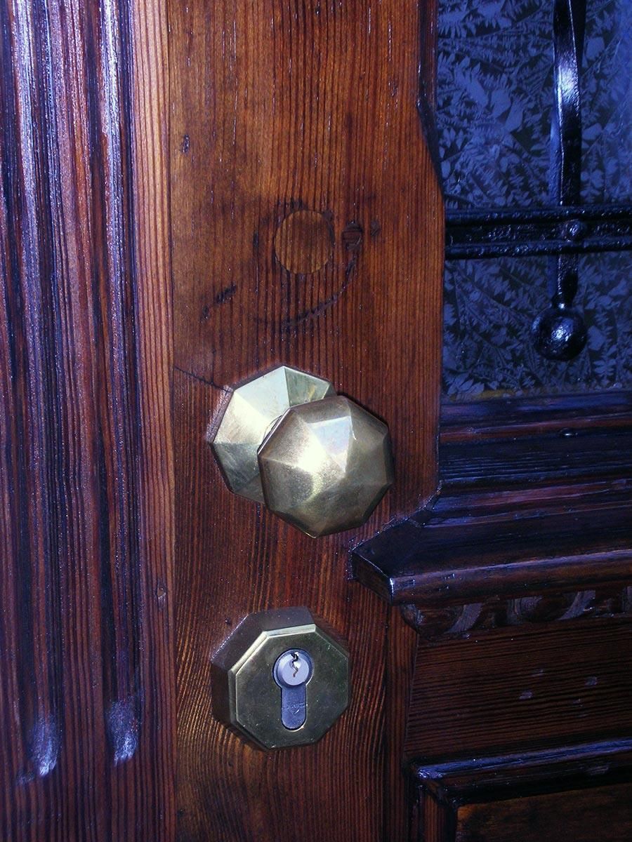 Eine Holztür mit zwei Messingknöpfen und einem Schlüssel
