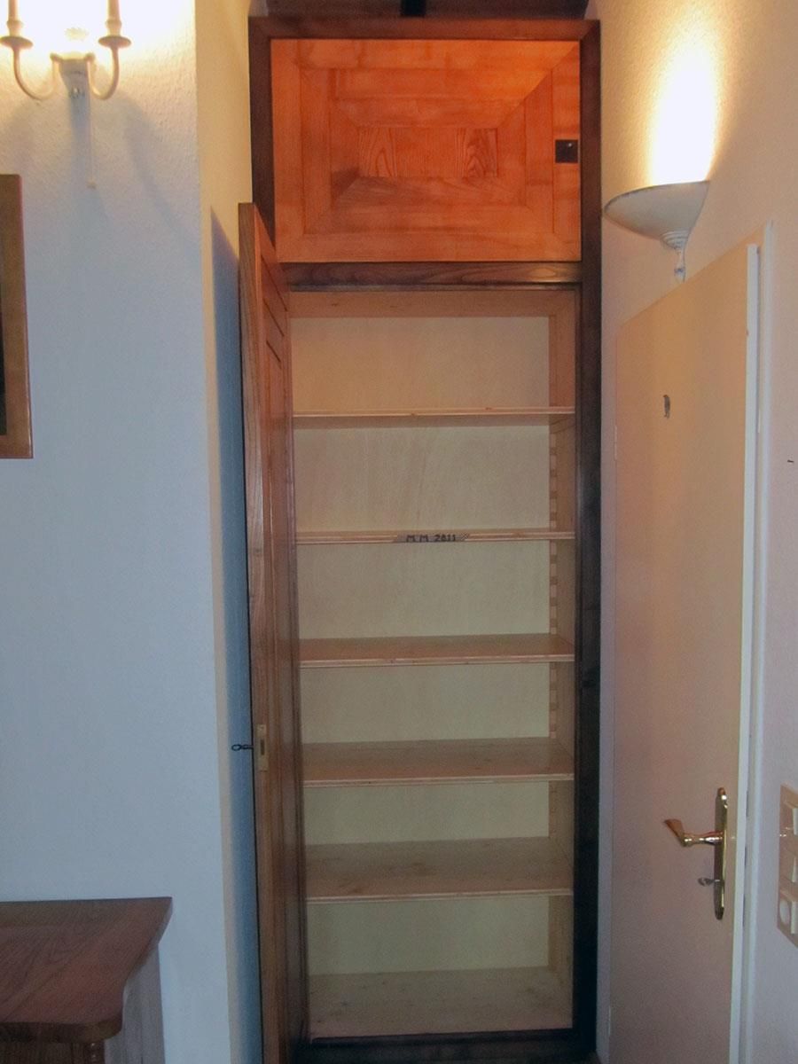 Ein Schrank mit offener Tür und einem Licht an der Wand