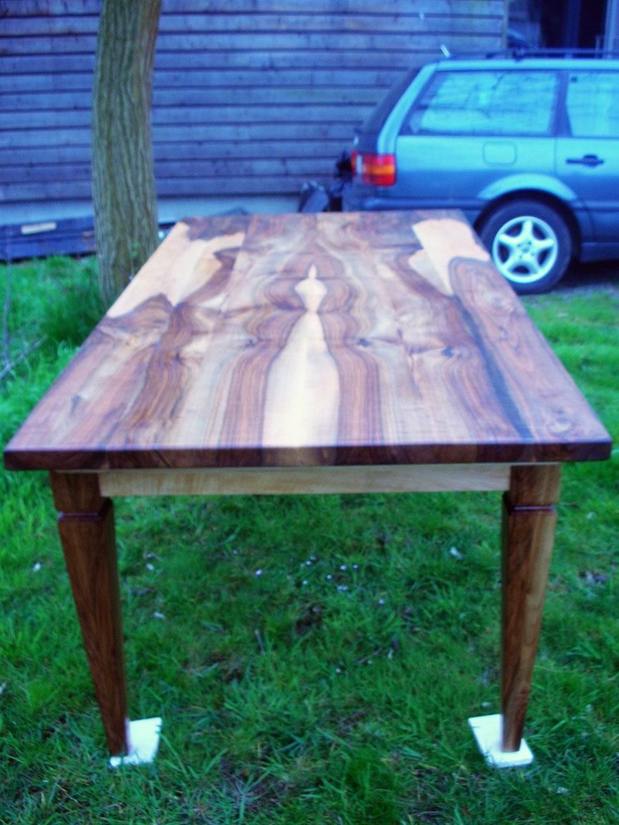 Ein Holztisch mit einem dahinter geparkten Auto