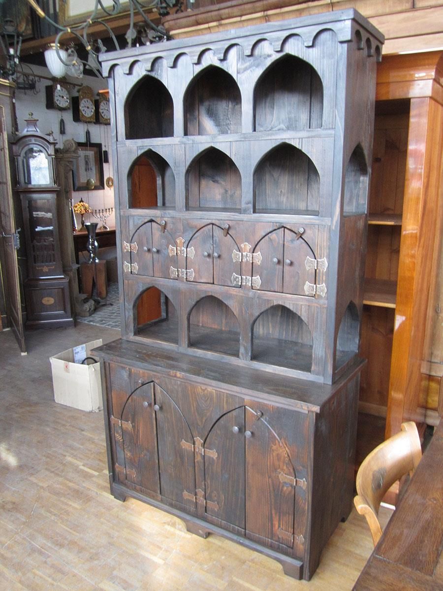 Ein großer Holzschrank mit gewölbten Regalen und Türen