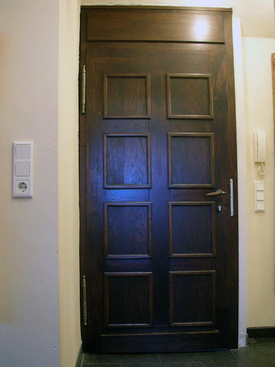 Eine dunkle Holztür mit Quadraten darauf