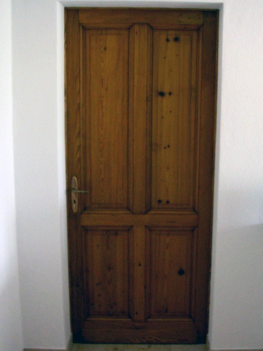 Eine Holztür mit einer weißen Wand dahinter
