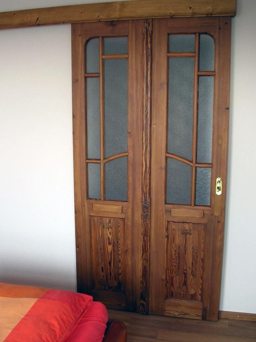 Ein Schlafzimmer mit einer Holztür und einem Bett