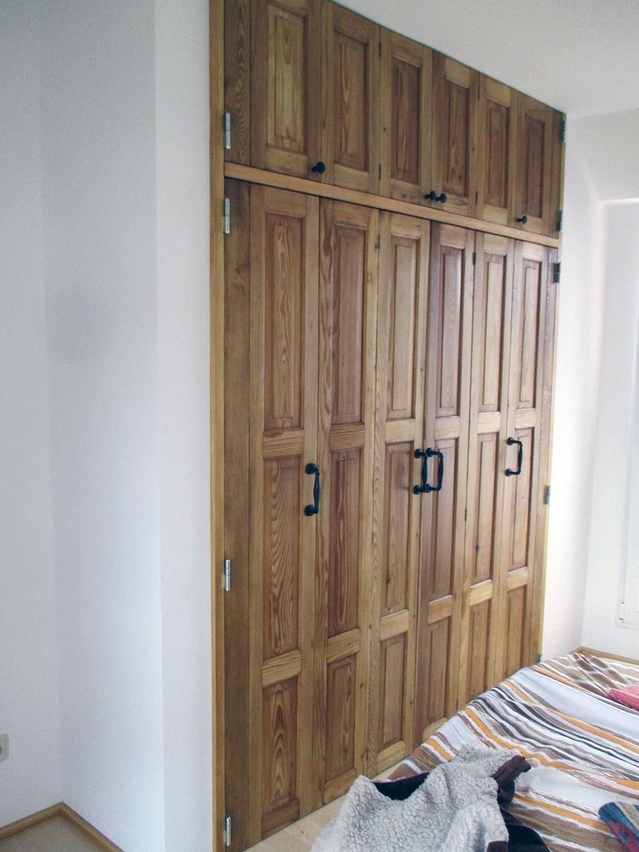 Ein Schlafzimmer mit Holzschränken und einem Bett