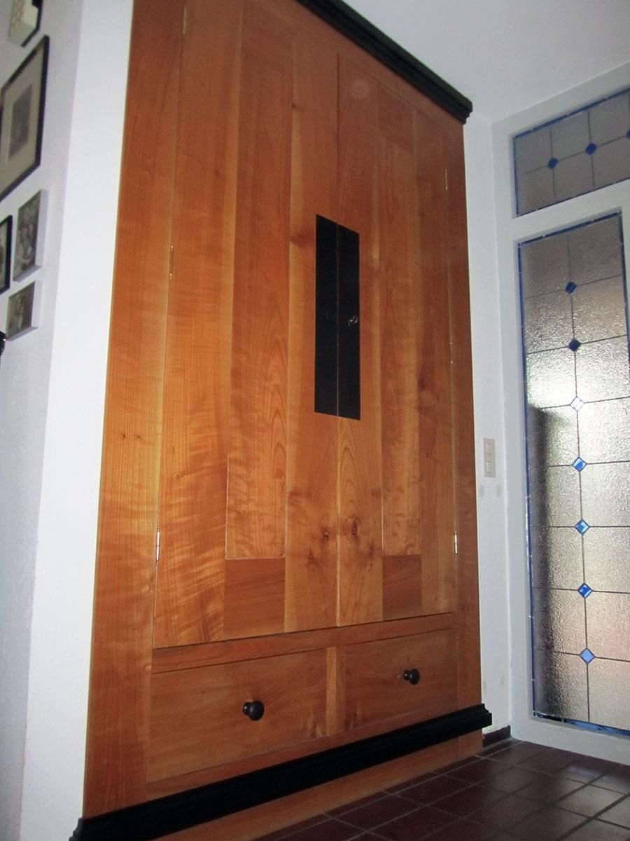 Ein Holzschrank mit Schubladen in einem Flur