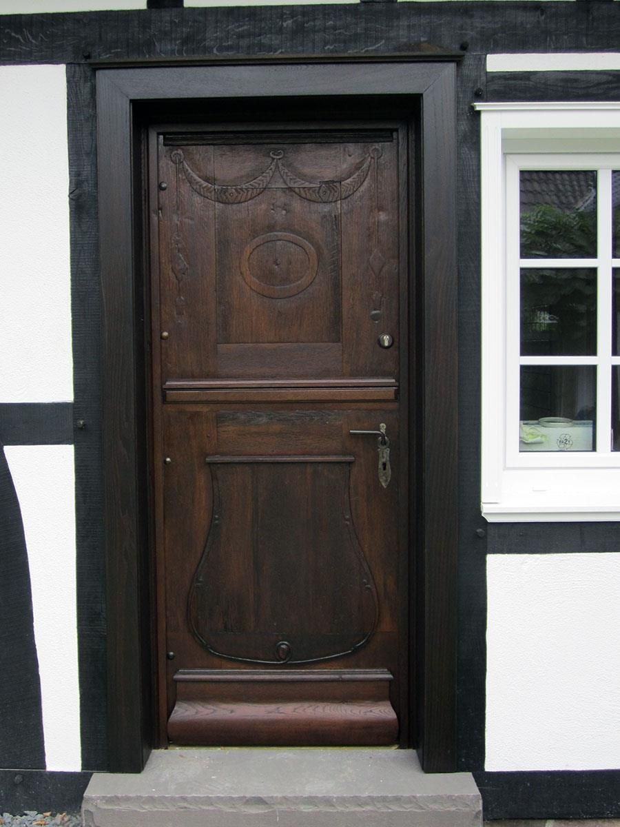 Ein schwarz-weißes Gebäude mit einer Holztür und einem Fenster