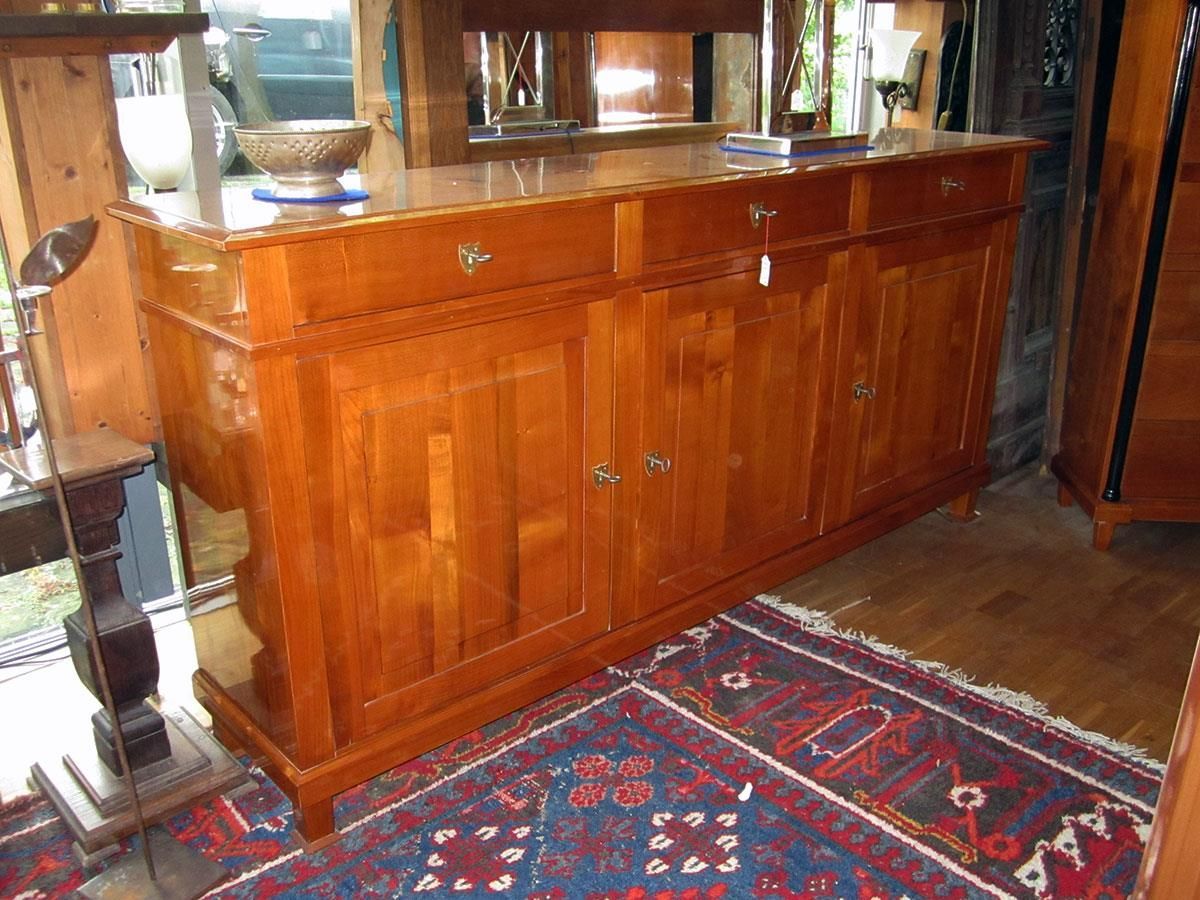 Ein Holzschrank mit Schubladen steht auf einem Teppich