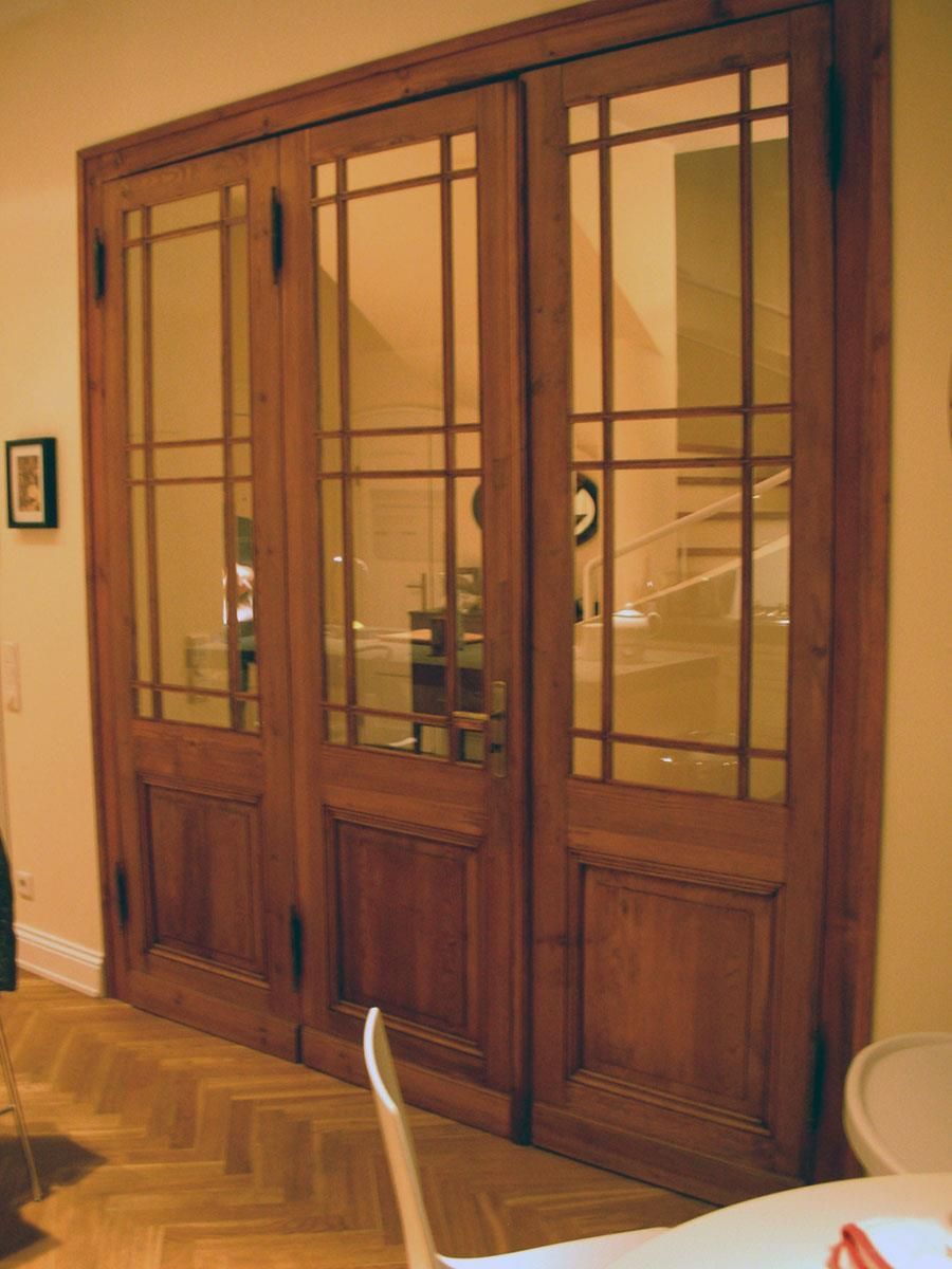 Ein Raum mit einem Tisch und Stühlen und einer Holztür