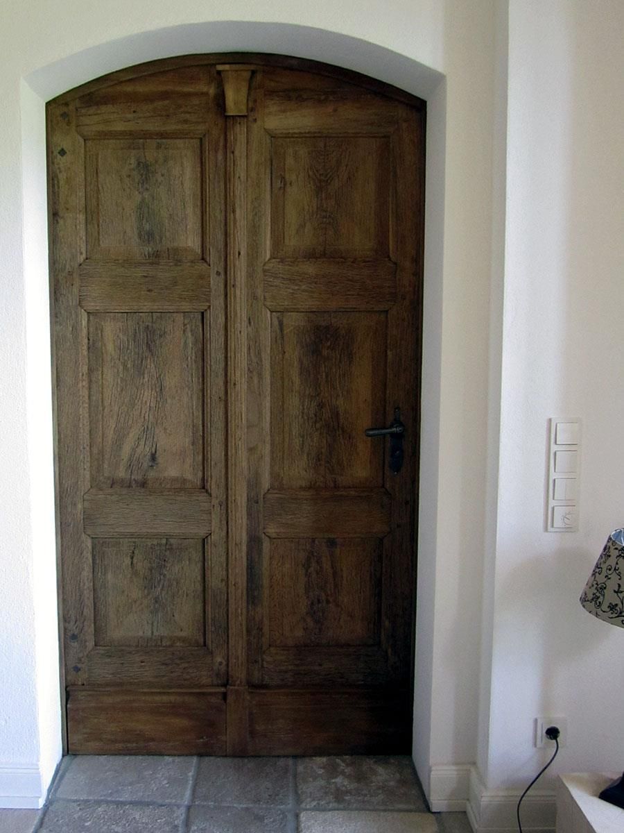 Eine Holztür mit einer weißen Wand dahinter