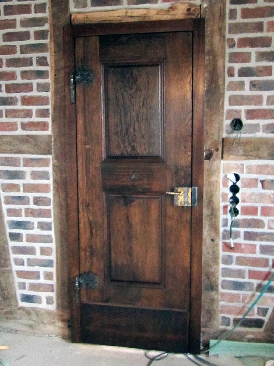 Eine Holztür vor einer Backsteinmauer