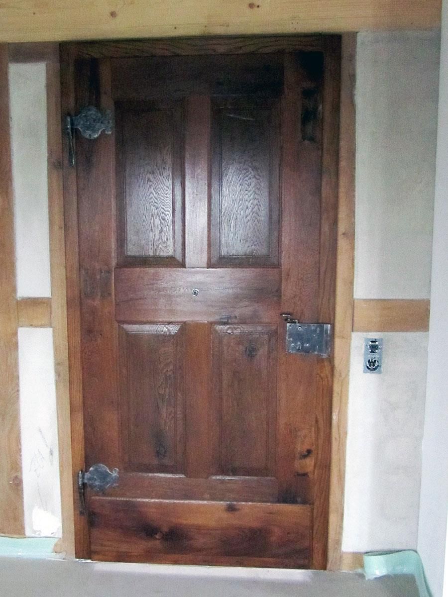 Eine Holztür in einem Raum mit einem Lichtschalter an der Wand