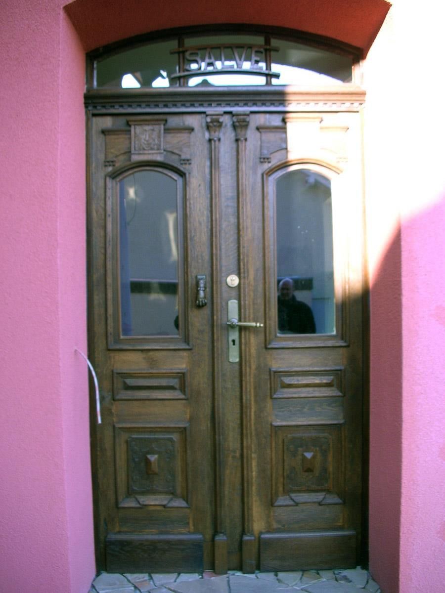 Eine Holztür mit einer rosa Wand dahinter