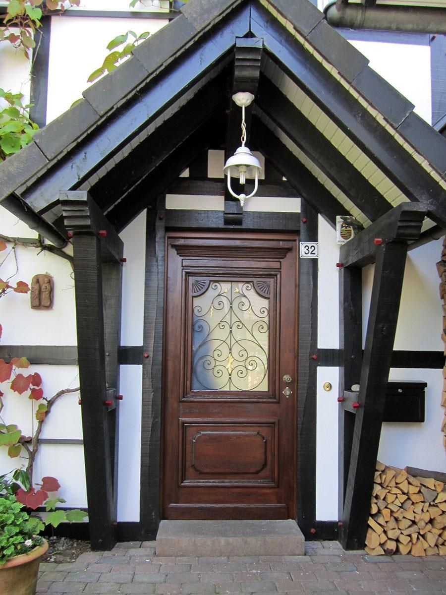 Ein schwarz-weißes Haus mit einer Holztür