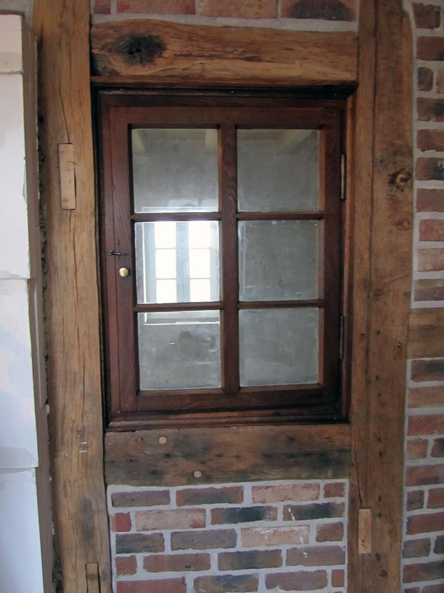 Ein Fenster in einer Ziegelwand mit einem Holzrahmen