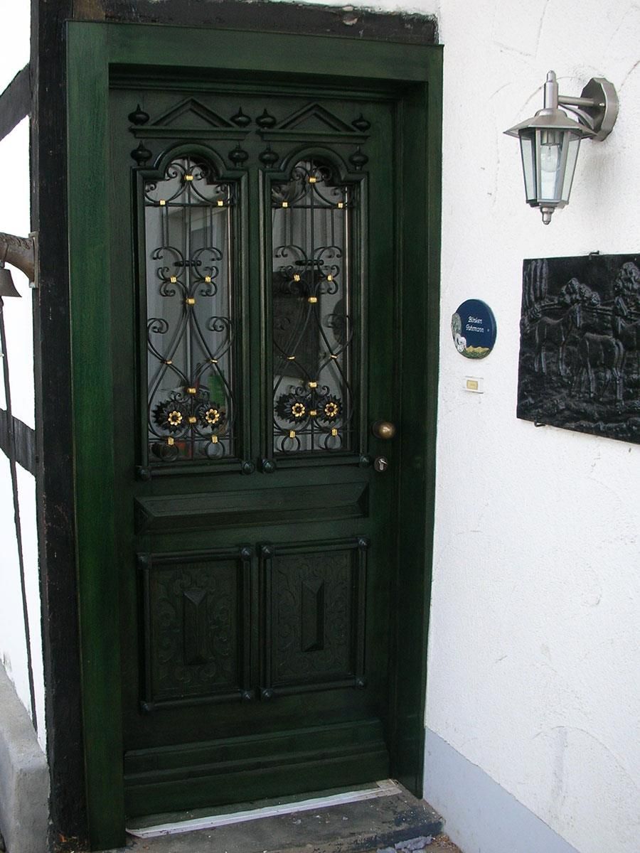 Eine grüne Tür mit einem schmiedeeisernen Design darauf