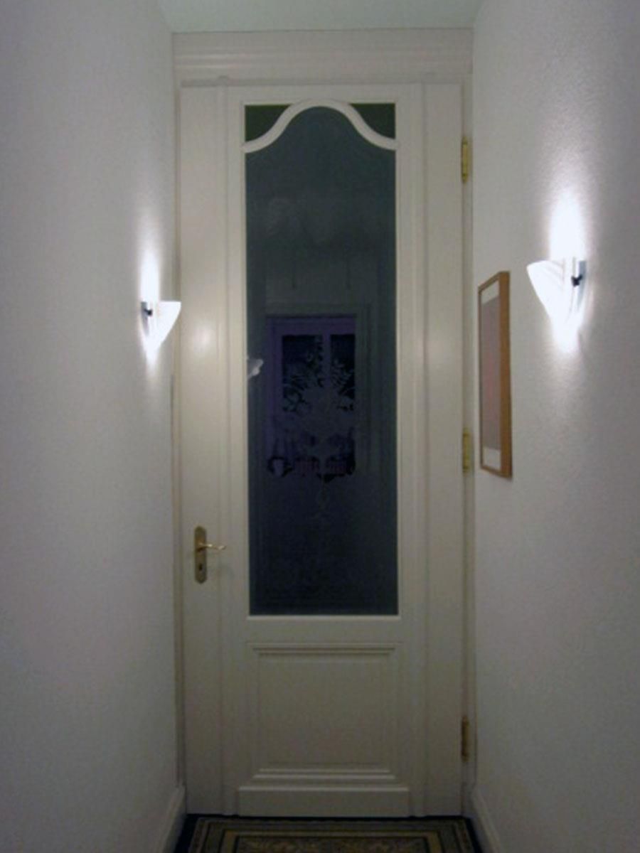 Ein Flur mit einer weißen Tür und einem Bild an der Wand