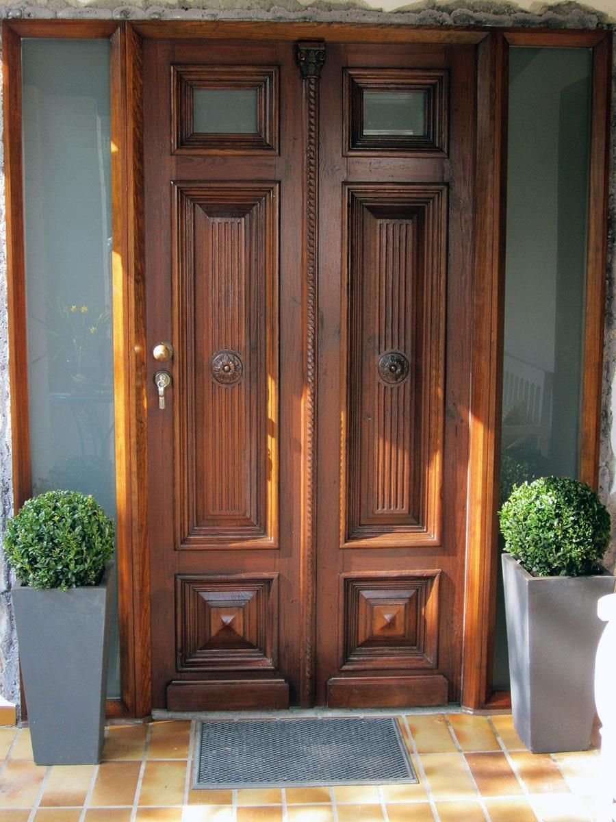 Eine Holztür mit zwei Topfpflanzen davor