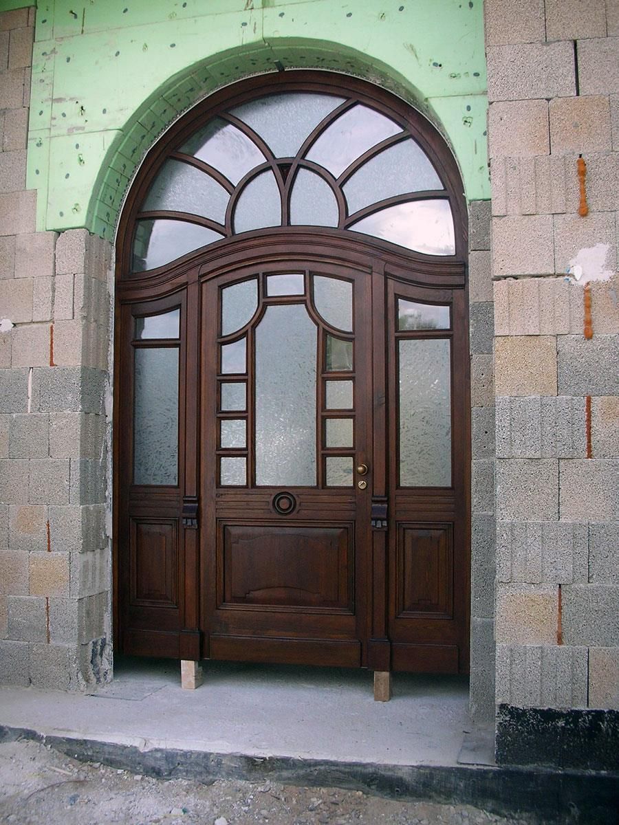 Eine Holztür mit einem grünen Rand ist von Ziegeln umgeben