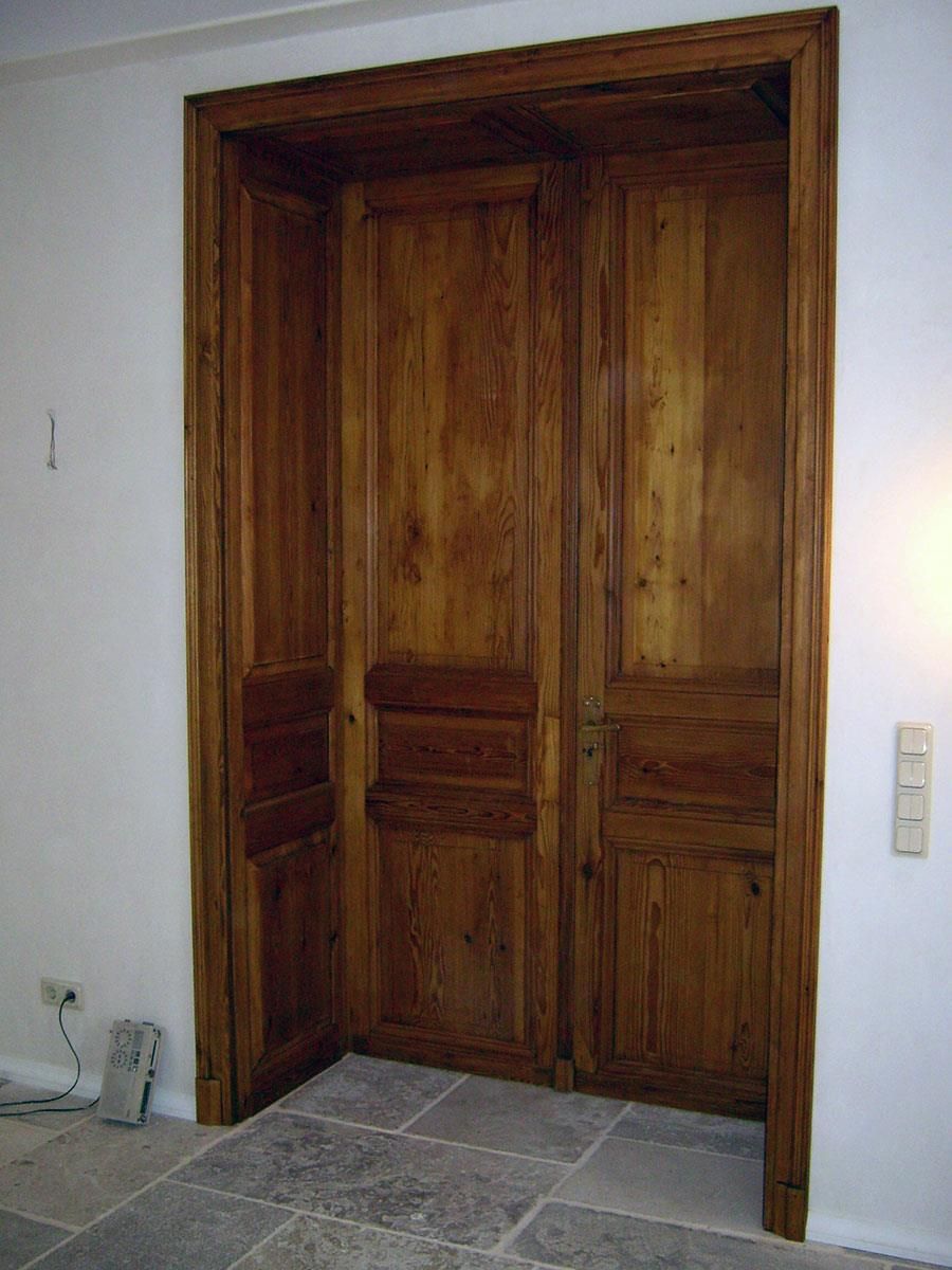 Eine Holztür mit der Nummer 1 an der Wand dahinter