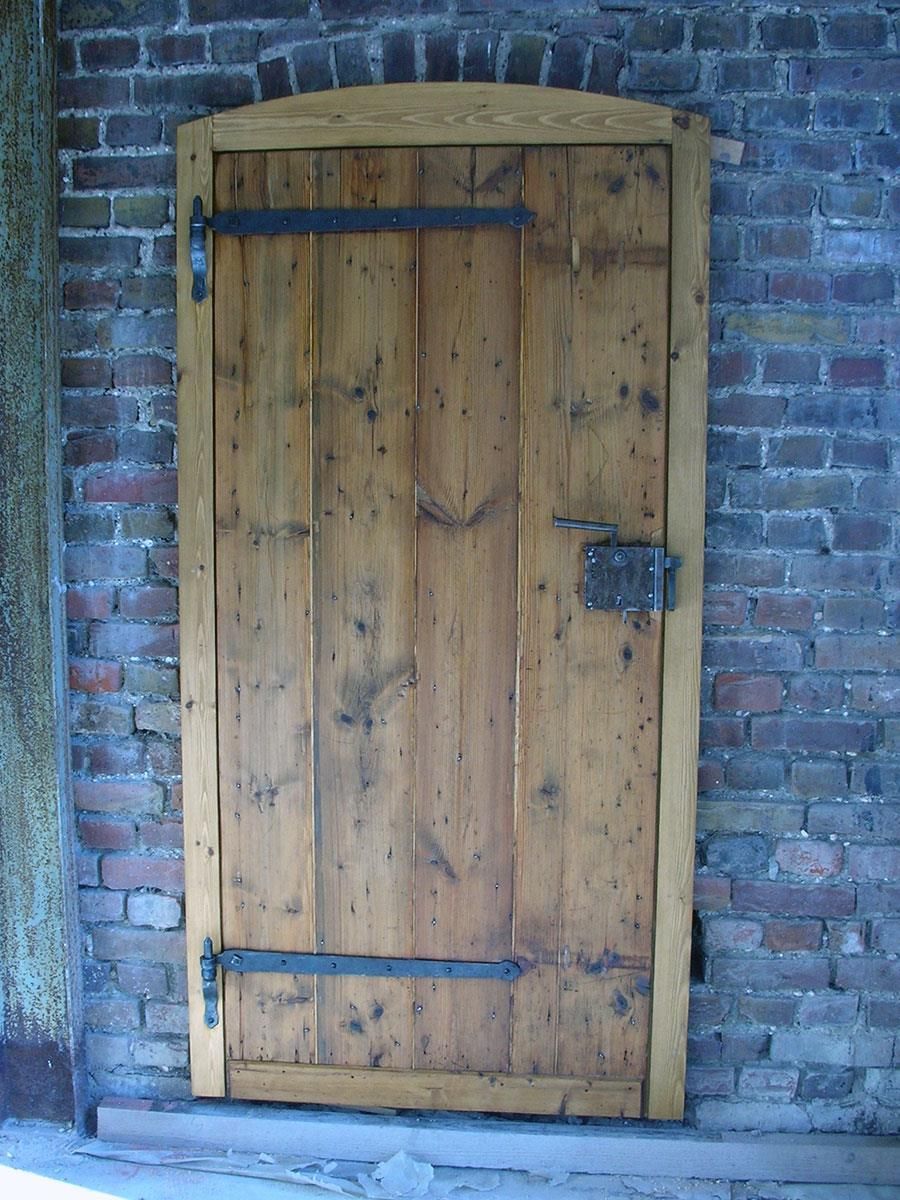 Eine Holztür steht an einer Ziegelwand