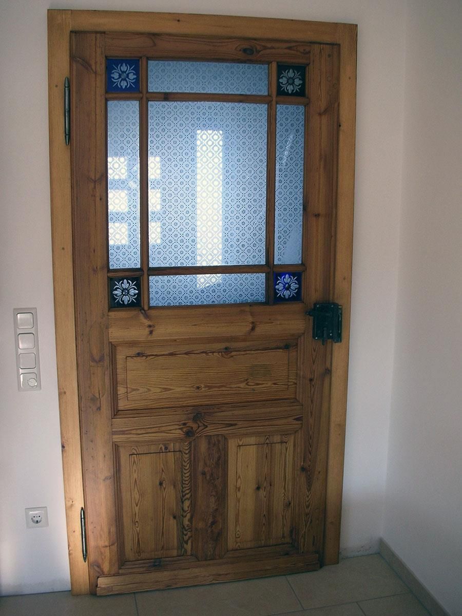 Eine Holztür mit einem Buntglasfenster