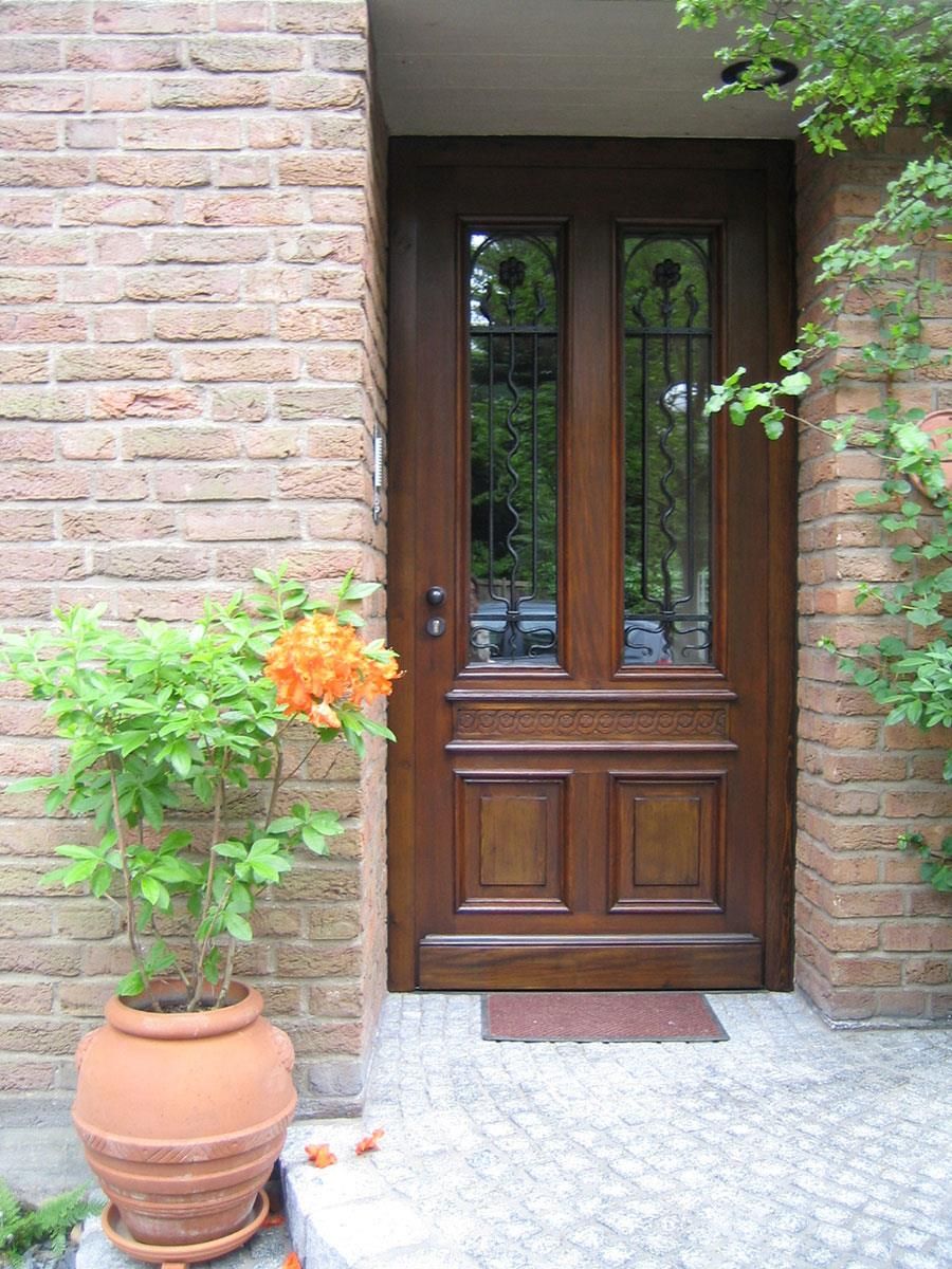 Eine Topfpflanze steht vor einer Holztür