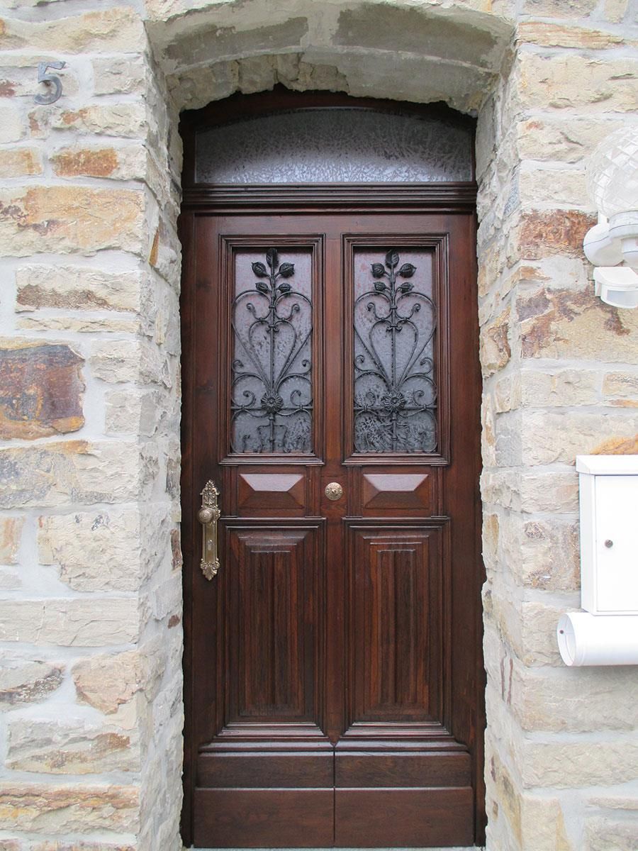 Eine Holztür mit einem schmiedeeisernen Design darauf