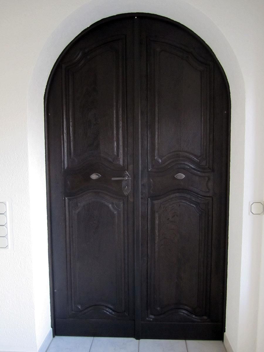 Eine schwarze Tür mit einer weißen Wand dahinter