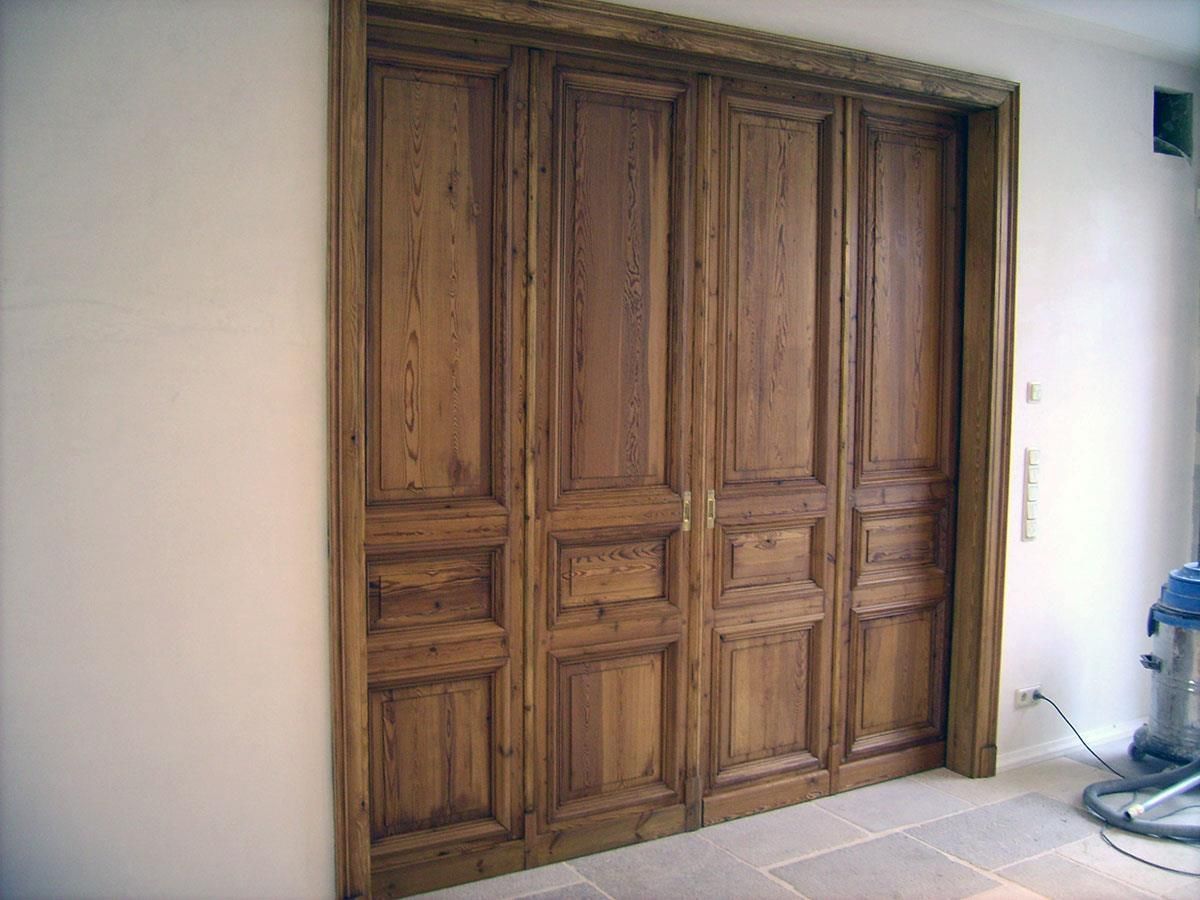 Ein Raum mit Holztüren und einem blauen Staubsauger