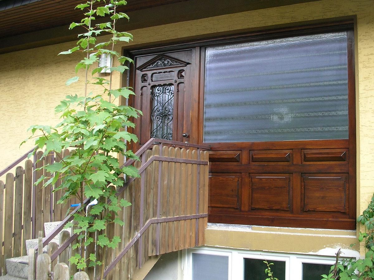 Ein Haus mit einer Holztür und einer Treppe, die dorthin führt