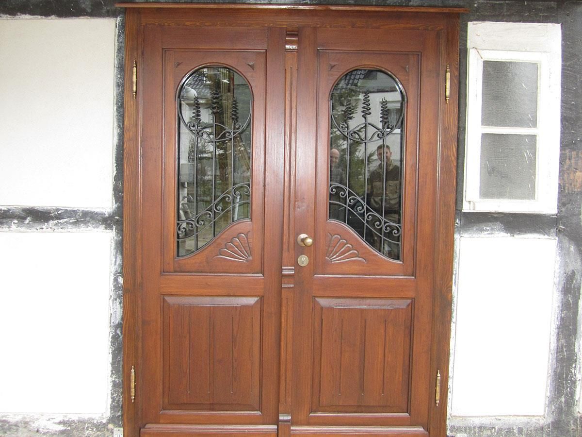 Eine Holztür mit einem schmiedeeisernen Zaun darum