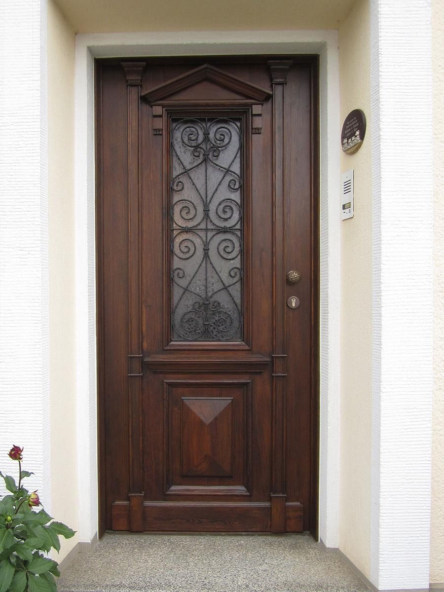 Eine Holztür mit einem schmiedeeisernen Design darauf