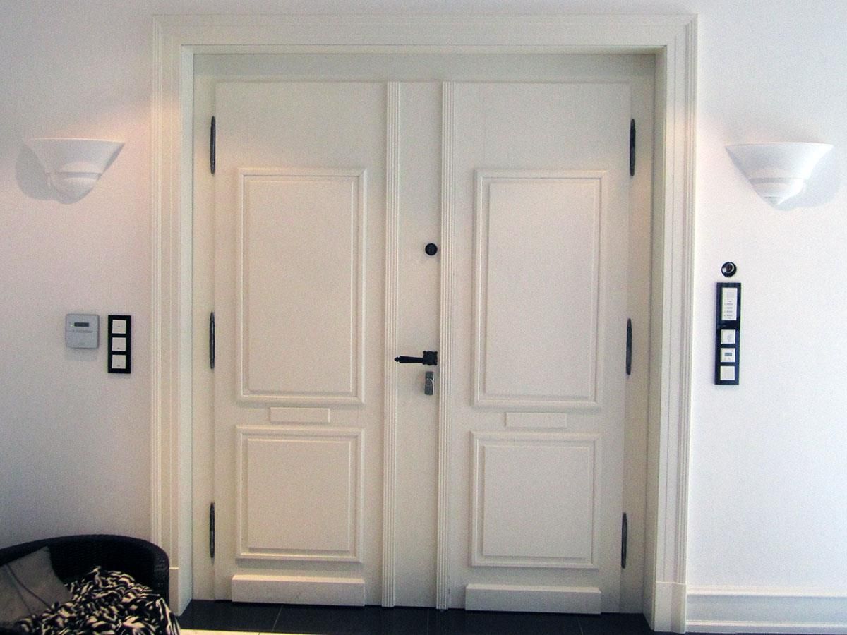 Eine weiße Tür mit einem schwarzen Griff in einem Zimmer