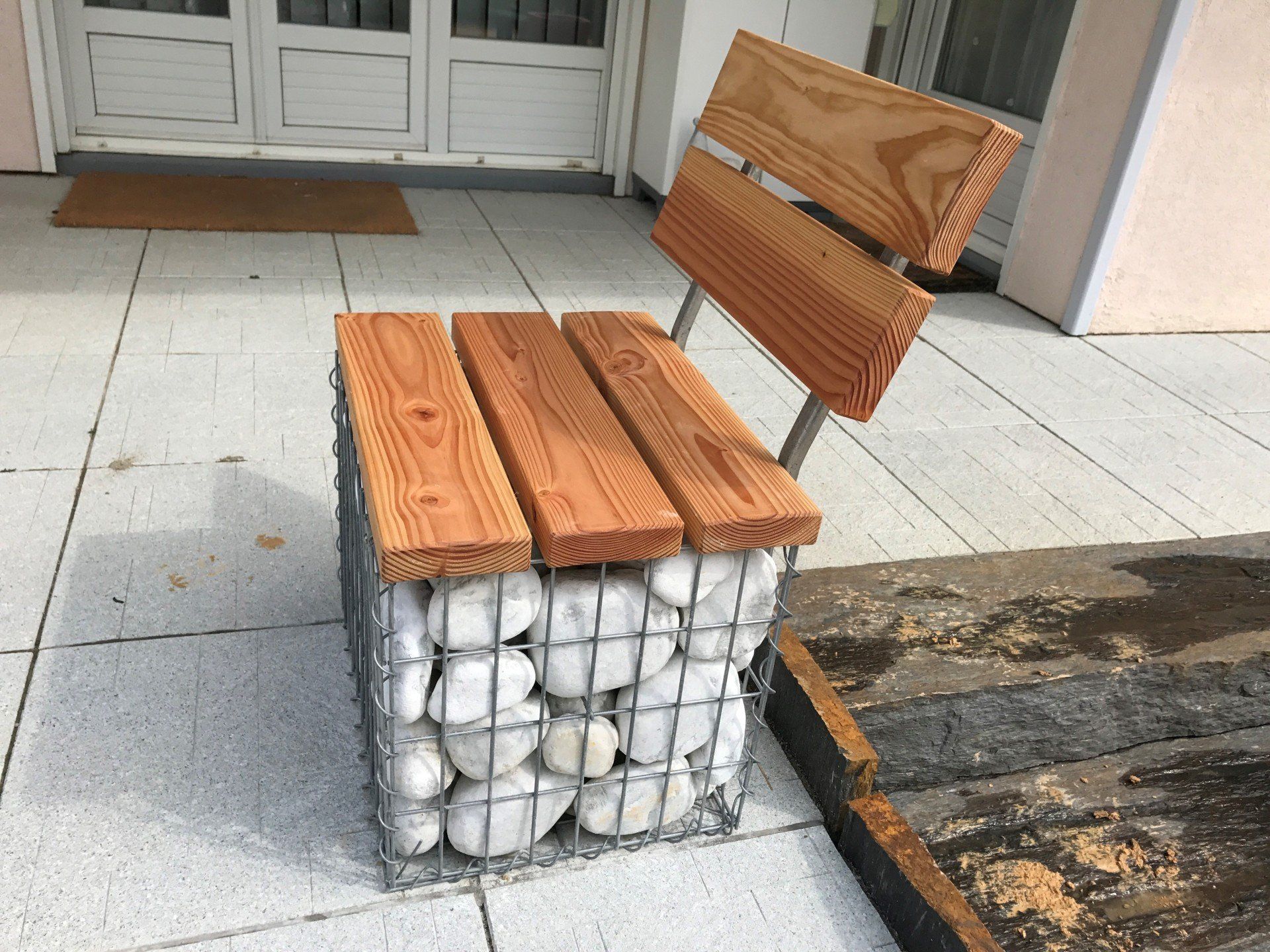 Banc en bois sur mesure avec des gros galets blancs pour faire la base