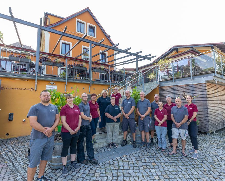 Eine Gruppe von Menschen posiert vor einem Gebäude für ein Foto.