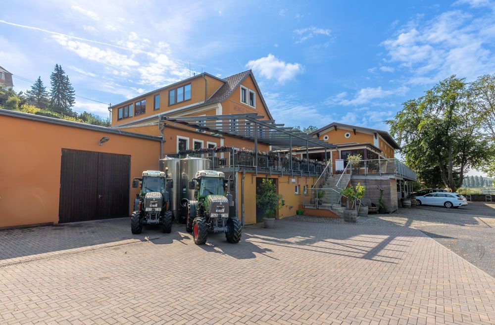 Drei Traktoren sind vor einem Gebäude geparkt.