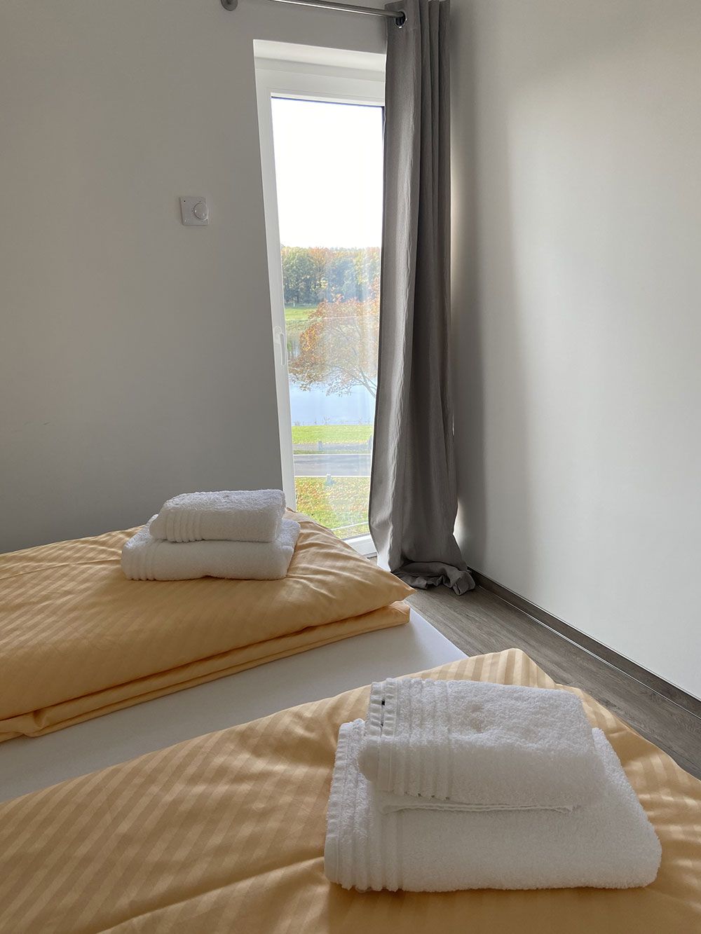 Ein Schlafzimmer mit zwei Betten und einer Glasschiebetür.