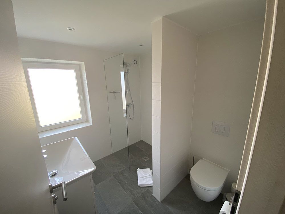 Ein Badezimmer mit Toilette, Waschbecken und Fenster