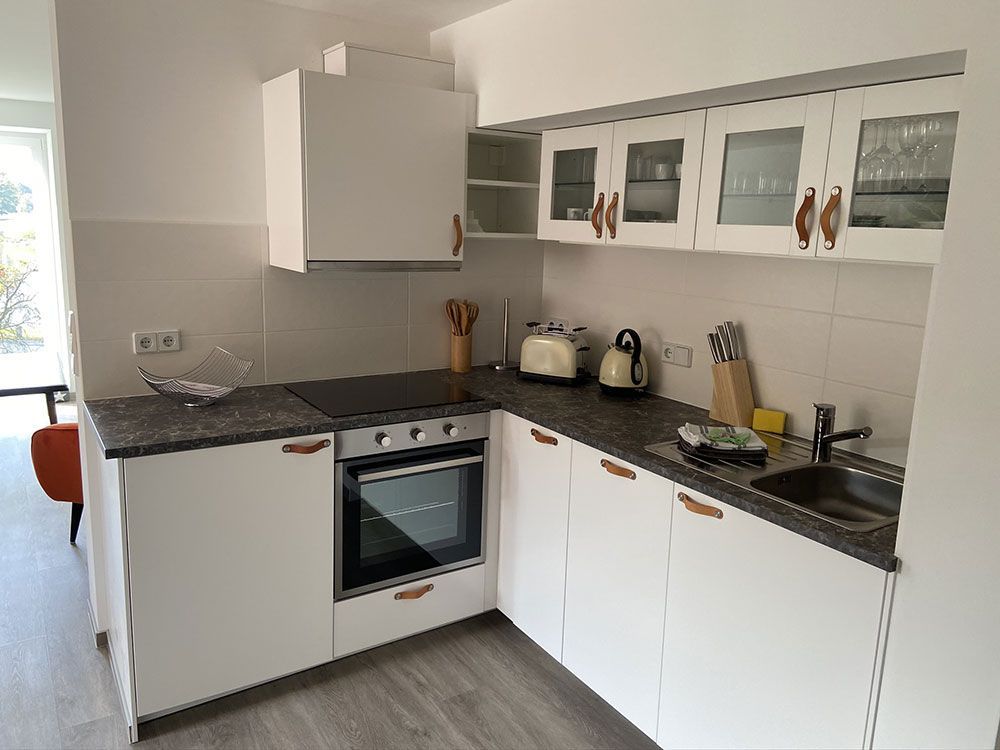 Eine Küche mit weißen Schränken und Geräten aus Edelstahl