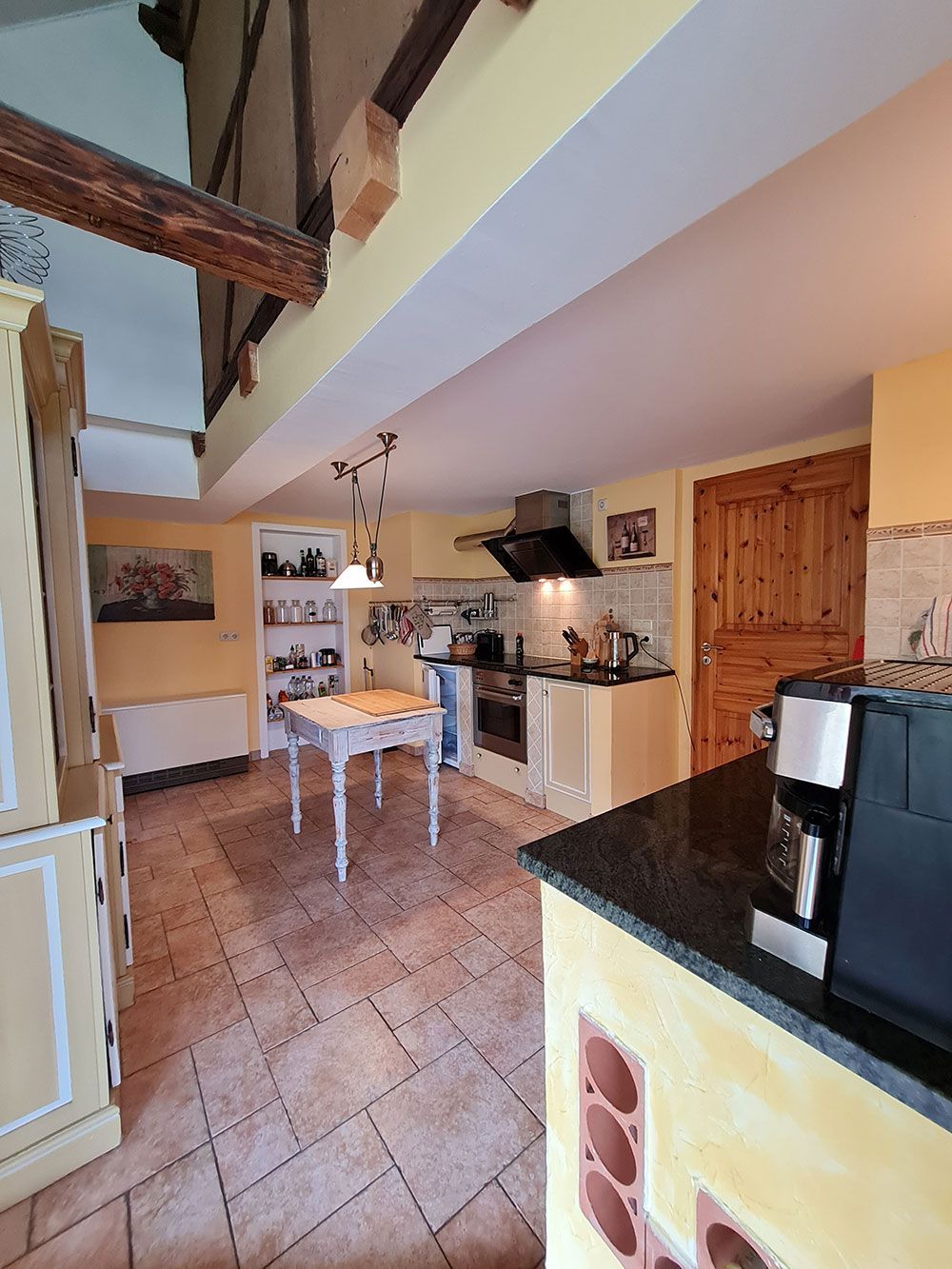 Eine Küche mit einem Tisch und einer Kaffeemaschine darin