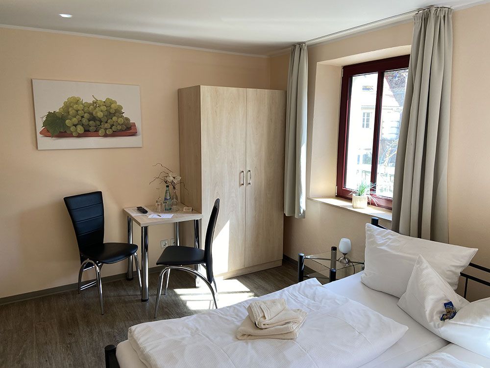 Ein Hotelzimmer mit Bett, Tisch und Stühlen.