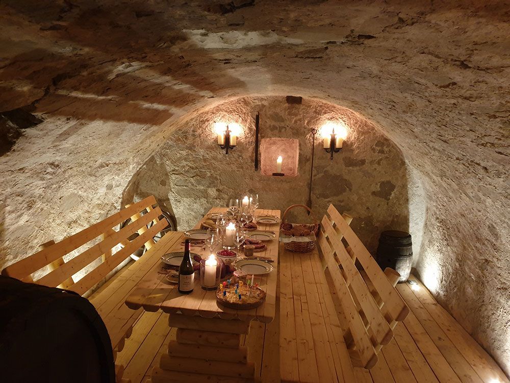 Ein Holztisch in einer Höhle mit Kerzen darauf