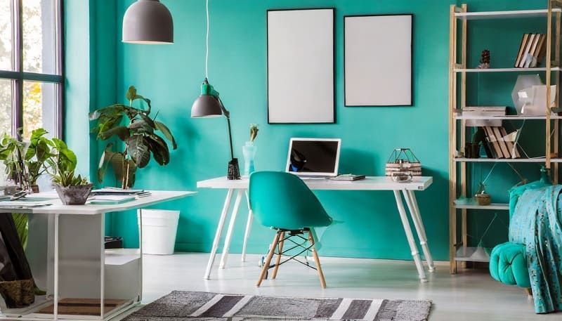 Ein Wohnzimmer mit türkisfarbenen Wänden und einem Schreibtisch mit einem Laptop darauf | MMJ Glas- und Gebäudereinigung